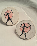 Round earrings with a design of a figure in a circle on a light background